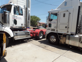 Two trucks side by side being serviced at K&C